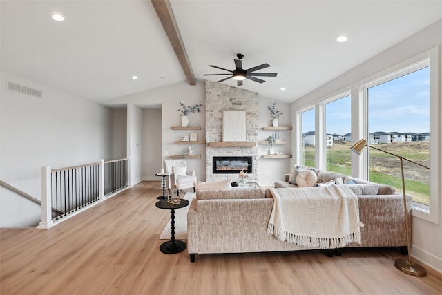 living room featuring light hardwood / wood-style floors, lofted ceiling with beams, a fireplace, and ceiling fan