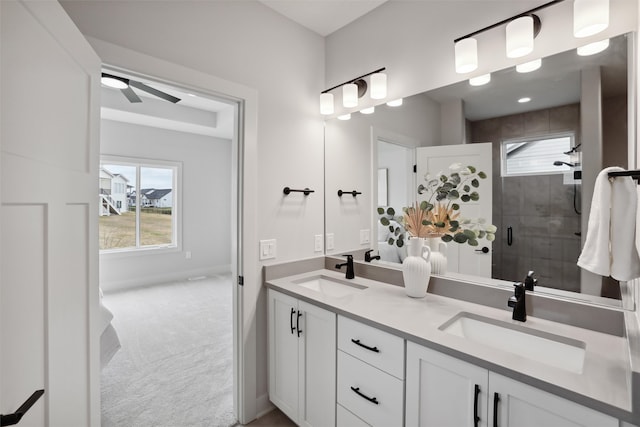 bathroom with vanity, a shower with shower door, and ceiling fan