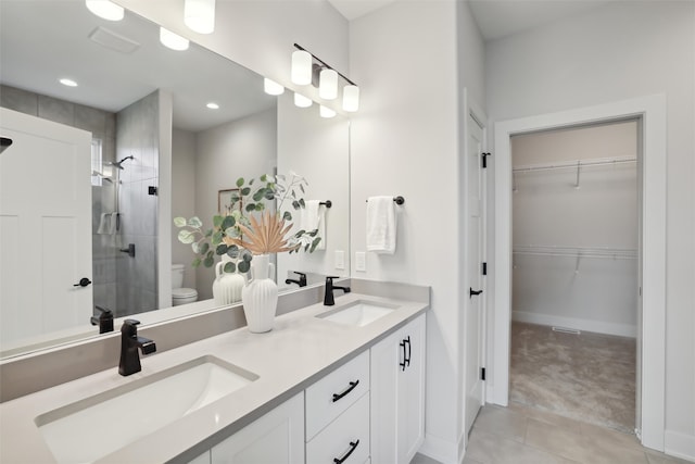 bathroom featuring vanity, tile patterned floors, toilet, and an enclosed shower