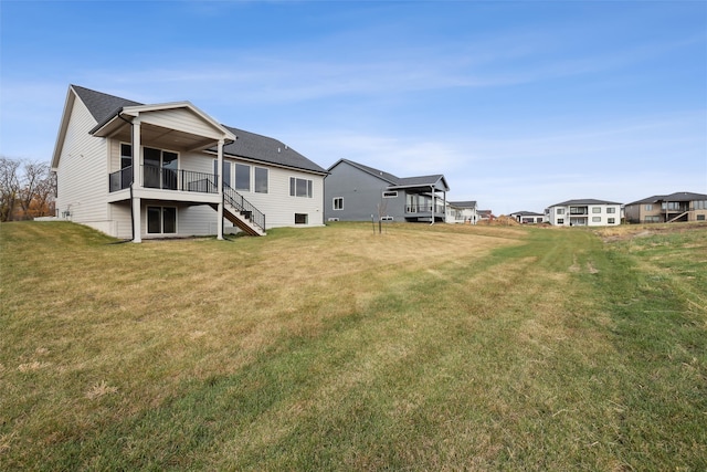 rear view of property featuring a wooden deck and a yard