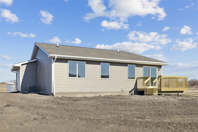 rear view of property featuring a wooden deck and central AC unit