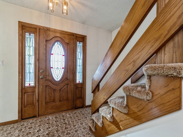 foyer entrance with a textured ceiling