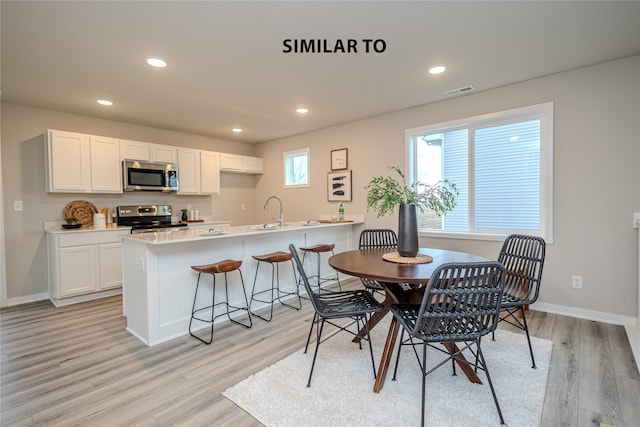 dining area with sink and light hardwood / wood-style flooring