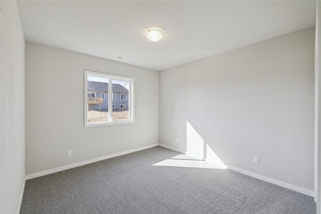 unfurnished room featuring baseboards, visible vents, and carpet flooring