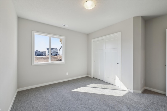 unfurnished bedroom with baseboards, visible vents, and carpet flooring