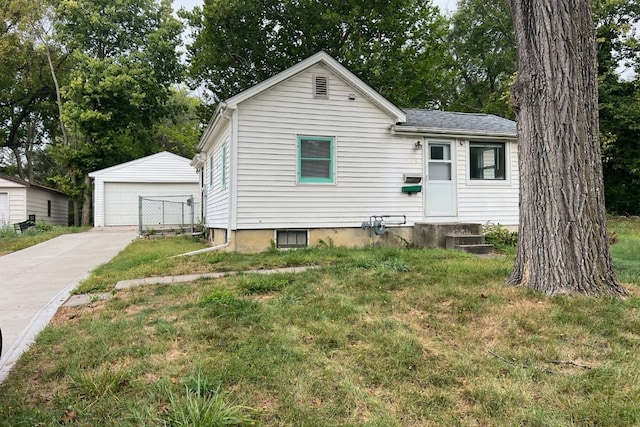 view of front of home featuring a front yard, a garage, and an outdoor structure