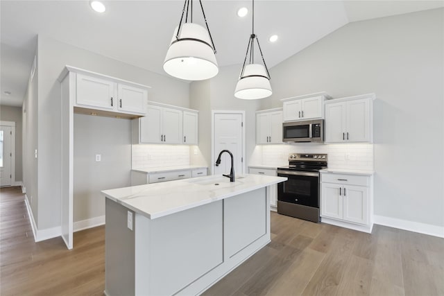 kitchen featuring pendant lighting, white cabinets, a center island with sink, sink, and stainless steel appliances