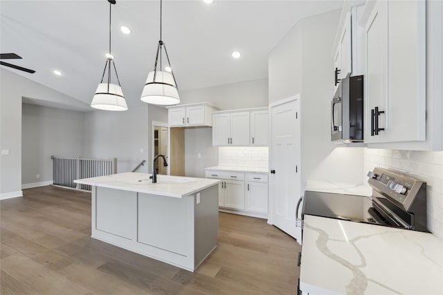 kitchen featuring a center island with sink, pendant lighting, white cabinetry, and stainless steel appliances