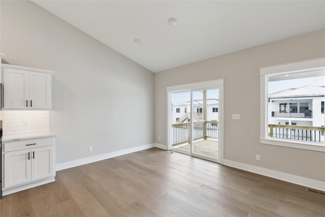 interior space featuring light hardwood / wood-style floors and lofted ceiling