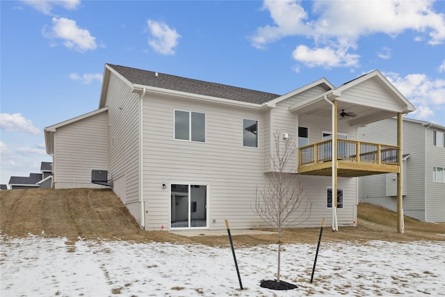 snow covered property featuring ceiling fan, a balcony, and central AC unit