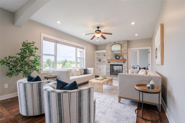 living room with a fireplace, dark wood-type flooring, and ceiling fan