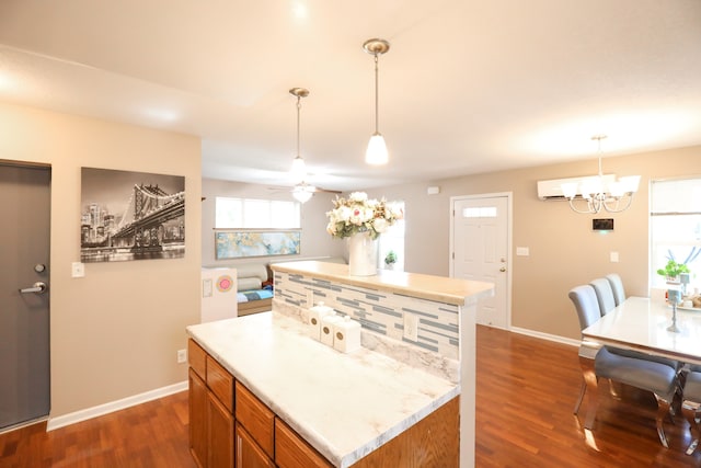 kitchen with pendant lighting, ceiling fan with notable chandelier, plenty of natural light, and dark hardwood / wood-style flooring