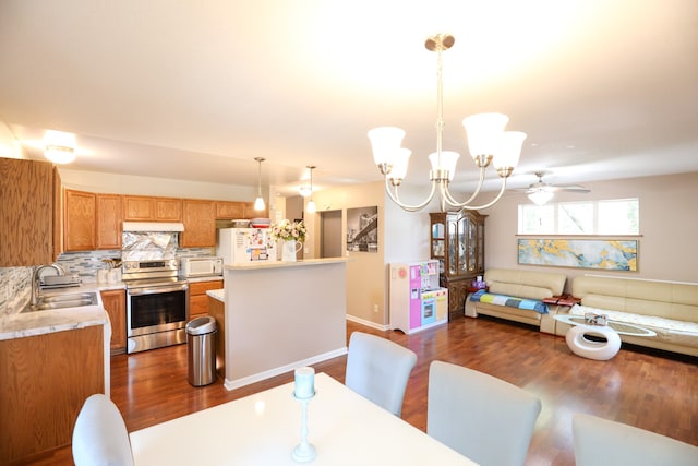 dining room with ceiling fan with notable chandelier, dark hardwood / wood-style floors, and sink