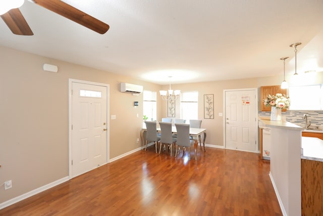 dining room with ceiling fan with notable chandelier, dark hardwood / wood-style flooring, sink, and a wall mounted air conditioner