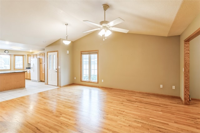 unfurnished living room with lofted ceiling, light hardwood / wood-style floors, ceiling fan, and a textured ceiling