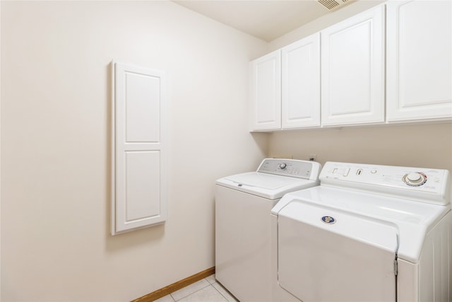 laundry area featuring cabinets, washing machine and clothes dryer, and light tile patterned floors