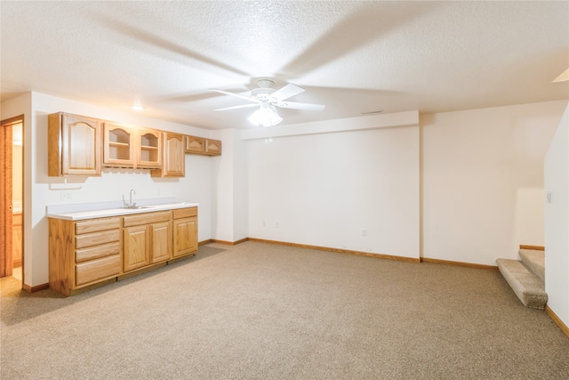 kitchen with a textured ceiling, ceiling fan, and light colored carpet