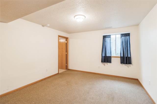 unfurnished room with a textured ceiling and carpet