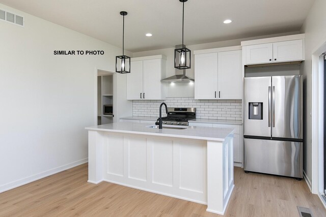 kitchen featuring white cabinetry, sink, an island with sink, and stainless steel appliances