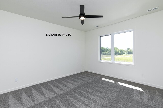 carpeted spare room featuring ceiling fan