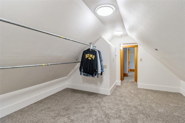 walk in closet featuring carpet floors and vaulted ceiling