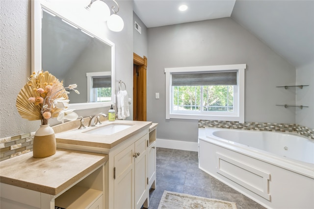 bathroom with vanity, a tub, vaulted ceiling, and tile patterned floors