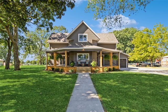 view of front of home with a garage, a front lawn, and covered porch