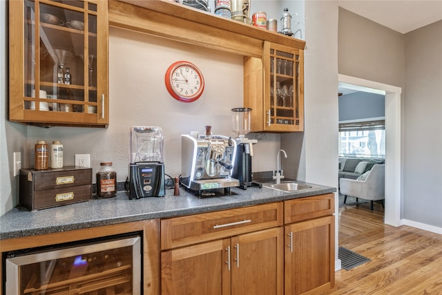 bar featuring light wood-type flooring, wine cooler, and sink