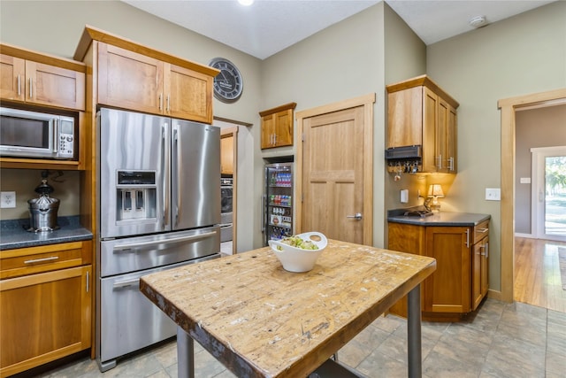 613 N State St, Pleasantville, IA 50225 - kitchen with dark countertops, brown cabinetry, and stainless steel appliances