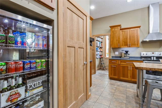 kitchen with light tile patterned floors, wine cooler, electric stove, and wall chimney range hood