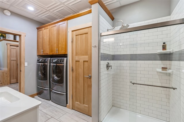 laundry area with washing machine and clothes dryer, cabinets, and sink