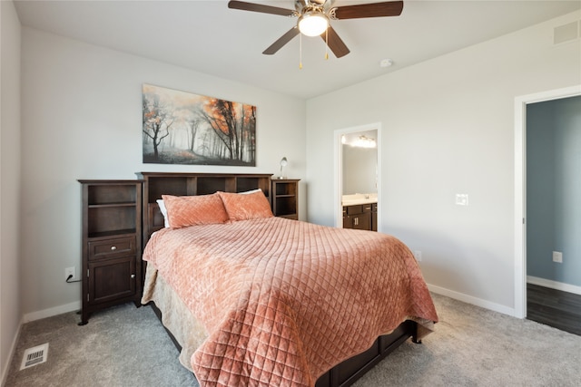 bedroom with ceiling fan, connected bathroom, and light carpet