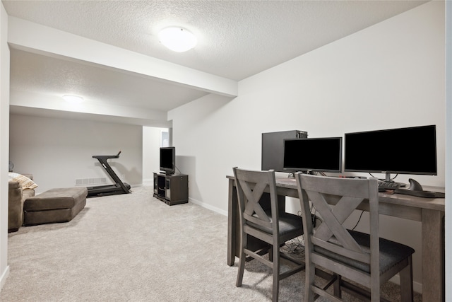 home office featuring carpet and a textured ceiling