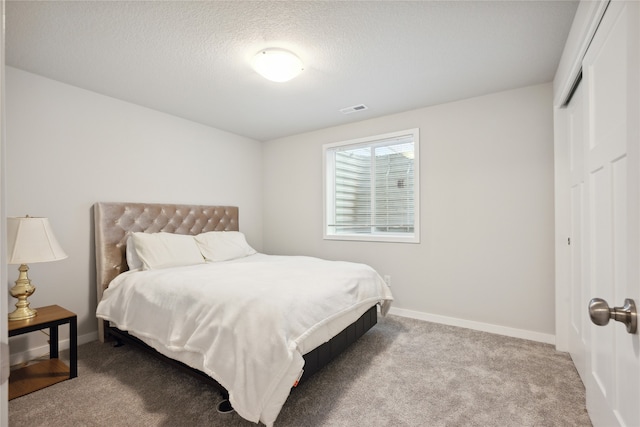 carpeted bedroom featuring a textured ceiling