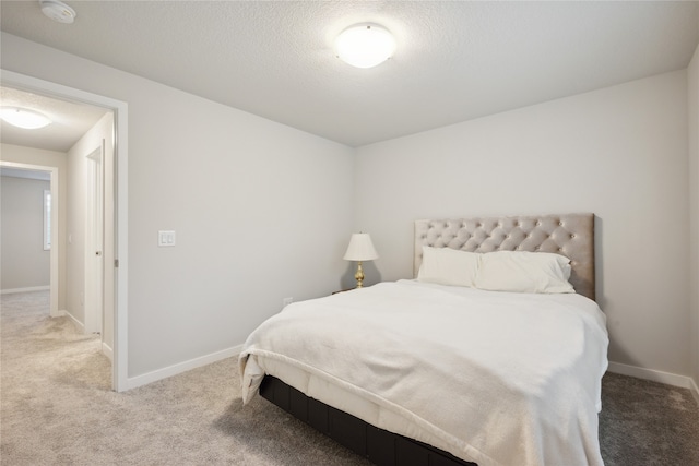 bedroom featuring a textured ceiling and carpet