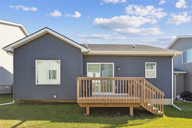 rear view of house featuring a lawn and a deck