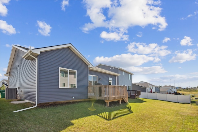 back of property with a yard, central air condition unit, and a wooden deck