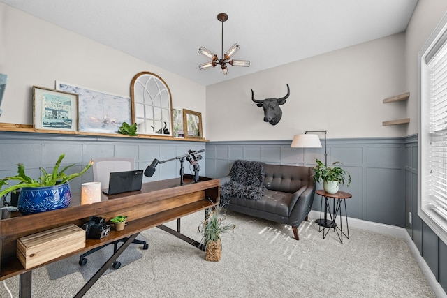 home office with an inviting chandelier and carpet flooring