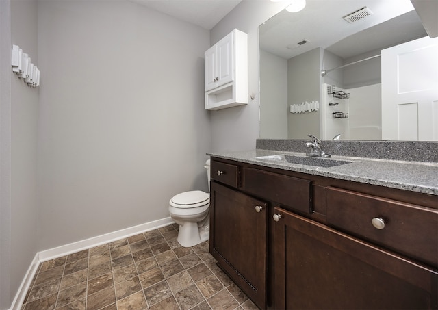 bathroom with walk in shower, vanity, and toilet