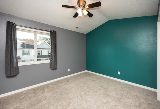 unfurnished room with vaulted ceiling, ceiling fan, light colored carpet, and a textured ceiling