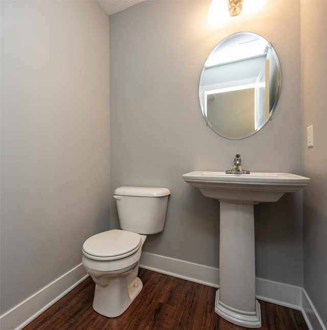 bathroom with wood-type flooring, sink, and toilet