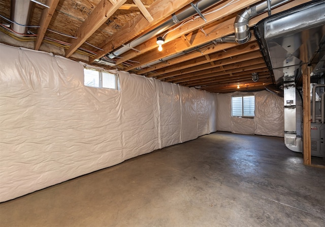 basement featuring heating unit and plenty of natural light