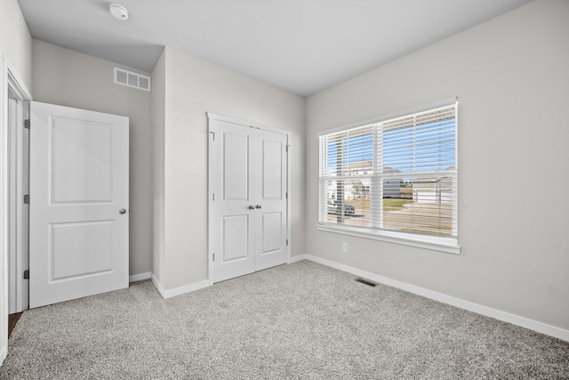 unfurnished bedroom featuring carpet flooring and a closet