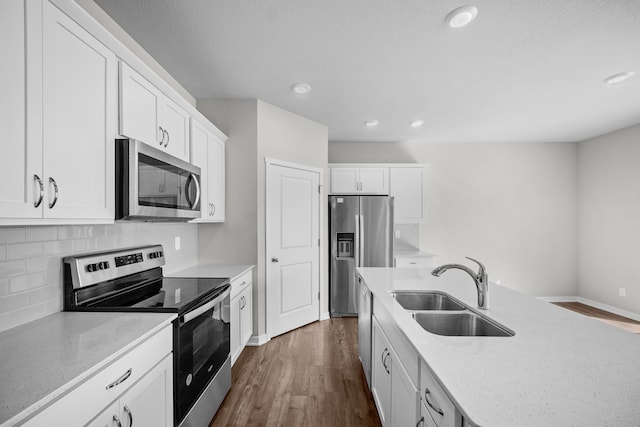 kitchen featuring dark wood-type flooring, tasteful backsplash, white cabinets, stainless steel appliances, and sink