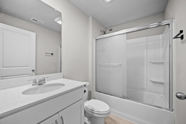 full bathroom featuring bath / shower combo with glass door, vanity, and toilet