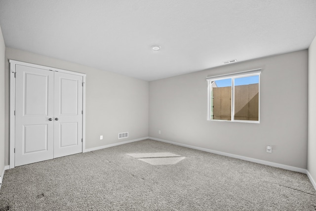 unfurnished bedroom featuring carpet flooring and a closet