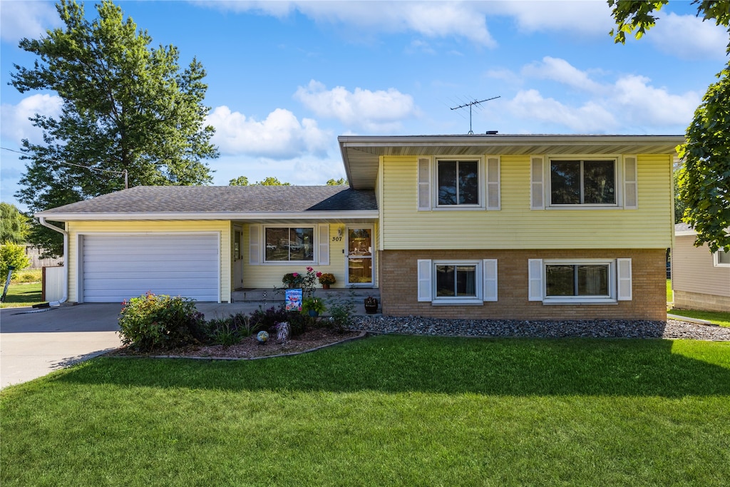 split level home featuring a front yard and a garage