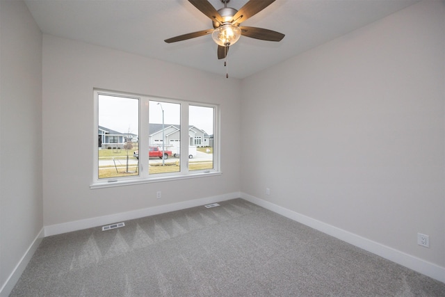 carpeted spare room featuring ceiling fan