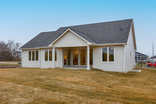 rear view of property featuring a patio and a lawn