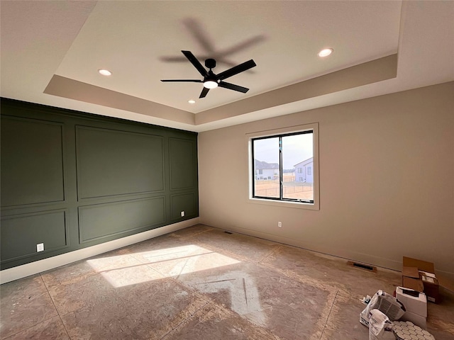 unfurnished bedroom featuring a raised ceiling and ceiling fan